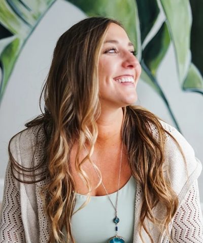 Photo of Kaitlin Muller-Cusack against a leaf-patterned background